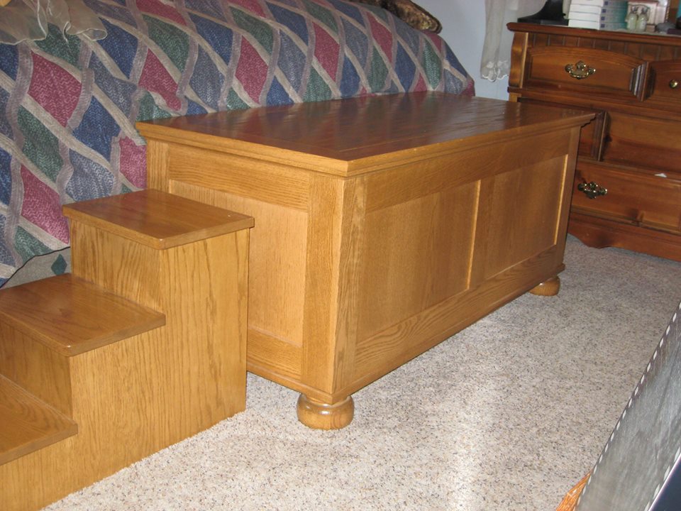 Red oak blanket chest with steps to help the family pet meet the challenge of the bed height.